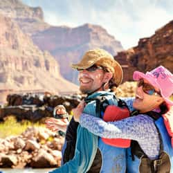 Couple sitting on river raft in Grand Canyon